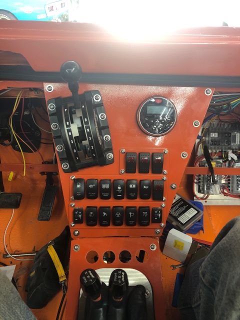 1992 Jeep Wrangler - The interior of a vehicle shows a custom dashboard with many switches and a gear selector.