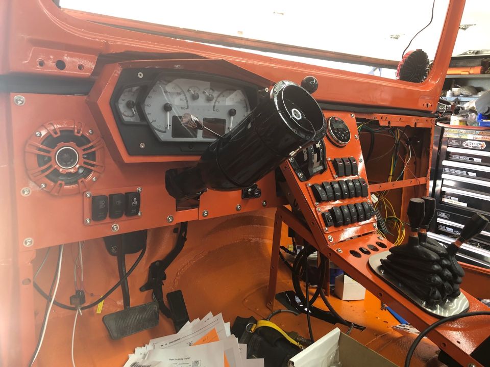 Orange interior with custom dashboard, aftermarket gauges, and numerous switches