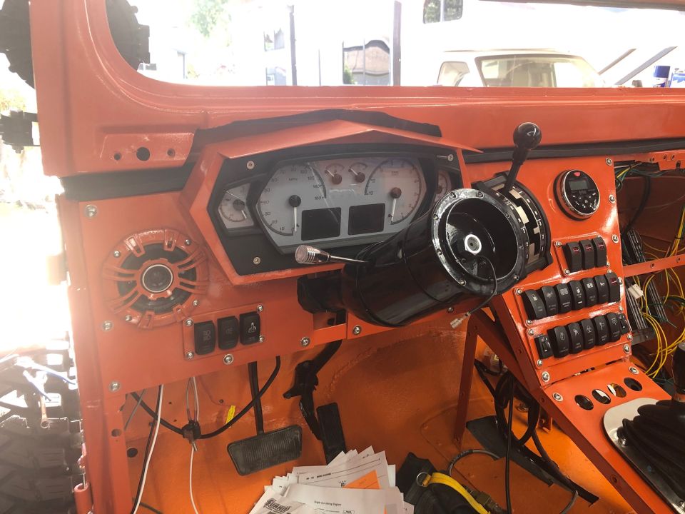 Custom dashboard with aftermarket gauges and numerous switches. Steering column is visible