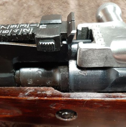 2003 Ford F-250 - Detailed view of a rifle's bolt and receiver assembly, showing various markings and the rear sight mechanism.