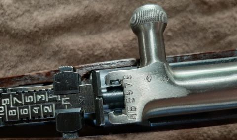2003 Ford F-250 - Detail of a rifle's bolt action mechanism and adjustable rear sight.