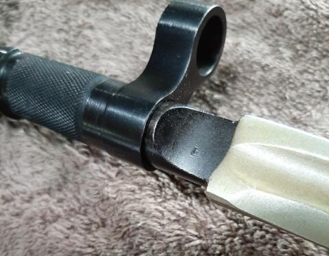 2003 Ford F-250 - Close-up of a bayonet's hilt and blade attachment, with a textured grip.
