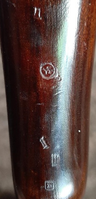 2003 Ford F-250 - Close-up view of wood grain showing several stamped markings and a circular emblem with a symbol inside.