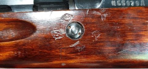 2003 Ford F-250 - Close-up view of a wooden stock with metal components and stamped serial number M65979A.