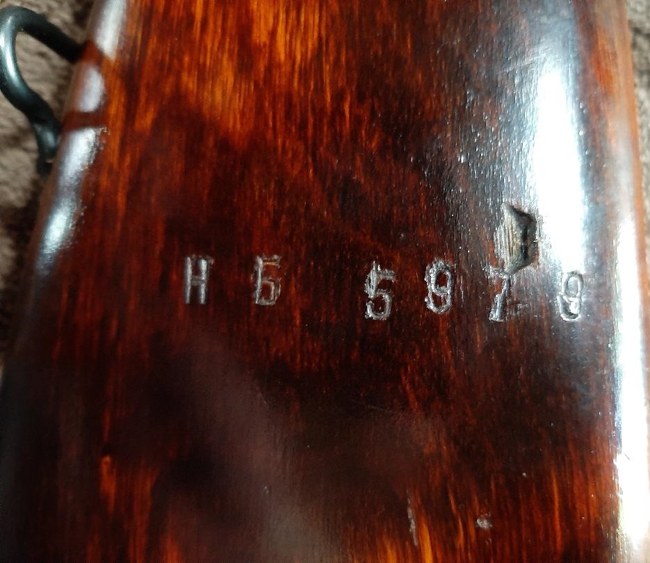 Close-up of a wooden surface with stamped serial number H 5 5979