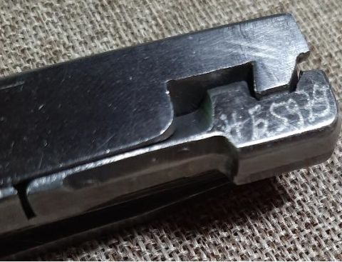 2003 Ford F-250 - A metal component with etched markings is shown against a textured background.