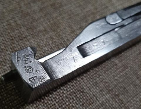 2003 Ford F-250 - Close-up of a metal tool showing various stamped symbols and numbers.