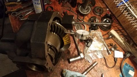 1985 Ford Bronco - A differential assembly is shown with a dial indicator and various tools, suggesting a measurement or adjustment process is underway.
