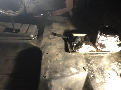 1978 Ford Bronco - A can of black paint and tools sit on the floor of a vehicle's interior.