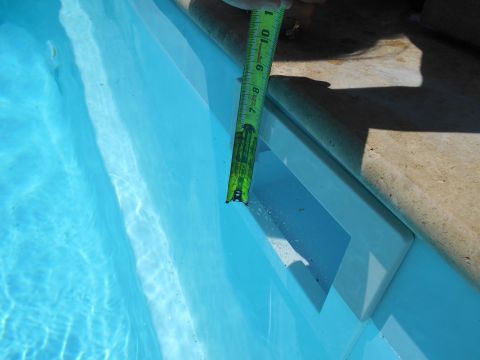 1992 Ford Bronco - A tape measure is used to check the depth of a swimming pool's steps.