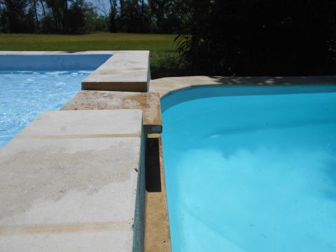 1992 Ford Bronco - A view of two swimming pools with a grassy area and trees in the background. The pools have blue and clear water.
