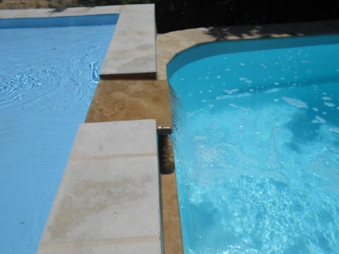 1992 Ford Bronco - A view of two adjacent swimming pools with clear blue water and stone coping surrounding them.