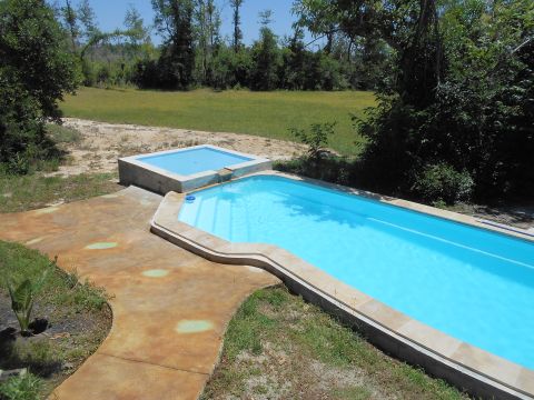 1992 Ford Bronco - Outdoor swimming pool and hot tub area with concrete patio and grassy surroundings.