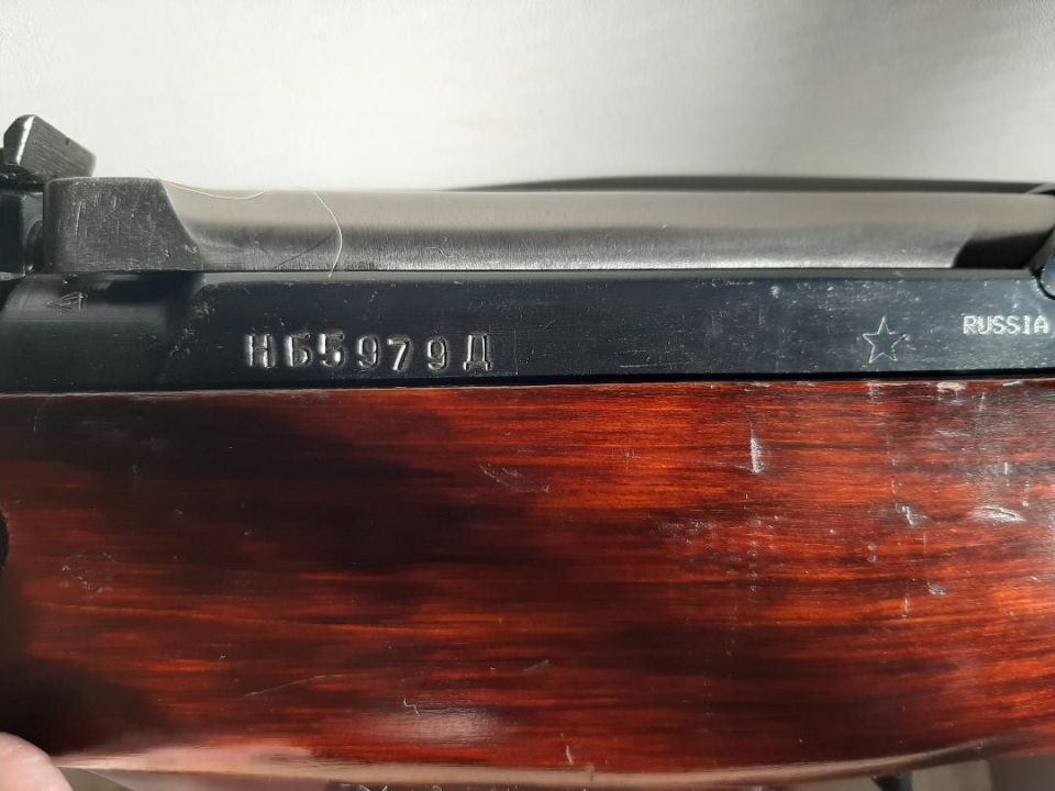 Rifle receiver with serial number H65979Д and "RUSSIA" marking, showing wood grain stock
