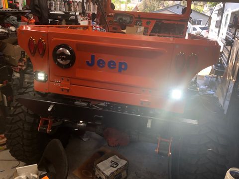 1992 Jeep Wrangler - The rear section of an orange Jeep is shown, custom modifications and large off-road tires.
