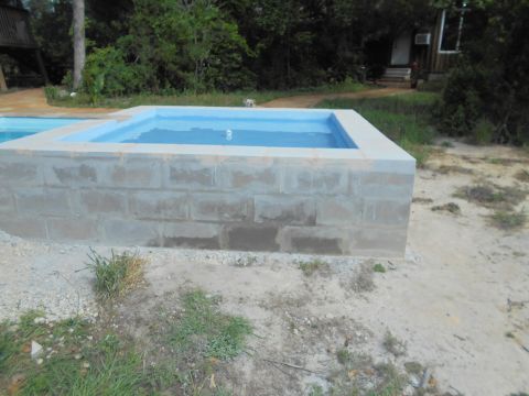 1992 Ford Bronco - Outdoor spa constructed from concrete blocks, with a blue water interior and surrounding natural landscape.
