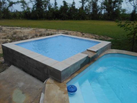 1992 Ford Bronco - A backyard scene two connected swimming pools with a waterfall feature.