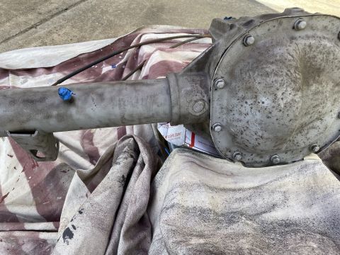 1994 Ford Bronco - A differential housing and axle tube are shown resting on a patterned cloth. A blue cap is visible on the axle tube, and the differential c…