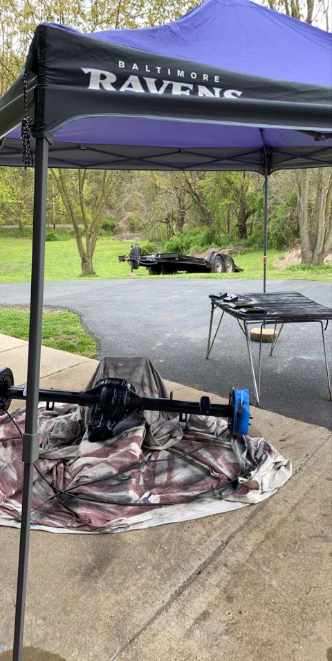1994 Ford Bronco - A black differential assembly is laid out on a tarp under a Baltimore Ravens branded canopy. A utility trailer is visible in the background…