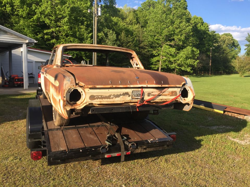 Heavily rusted 1962 Ford Galaxie on a trailer, missing windshield and headlights.