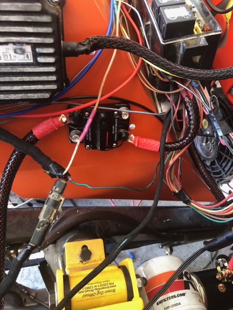 1992 Jeep Wrangler - A close-up view of a vehicle's wiring harness, featuring a black thermal circuit breaker with red wire connectors, a black braided cable, a…