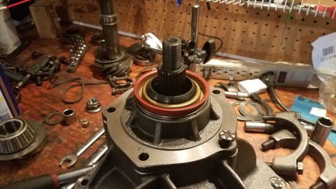 1985 Ford Bronco - A close-up view shows a differential housing with a splined shaft protruding from its center, surrounded by a red and gold seal. Various au…