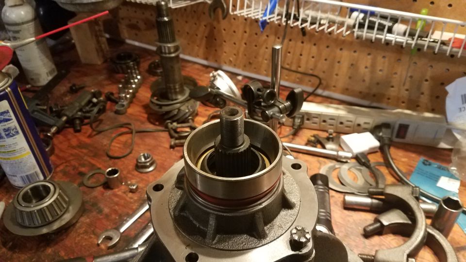 Vehicle differential or transmission part with tools and components on a workbench.