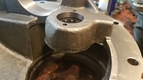 1985 Ford Bronco - Close-up view of a cast iron automotive part, possibly a spindle or knuckle, with a bearing installed in a bore. The part has a rough, text…