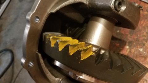 1985 Ford Bronco - A close-up view shows the teeth of a differential ring gear, marked with yellow paint, within a differential housing. The gears appear to b…