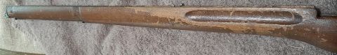 2003 Ford F-250 - This is a close-up, horizontal shot of a weathered wooden stock of a firearm. The wood has a worn, distressed appearance with areas of peel…
