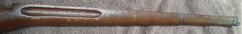 2003 Ford F-250 - This is a close-up, side view of a wooden rifle stock, likely from a vintage firearm. The wood shows signs of age and wear, with a long, ov…