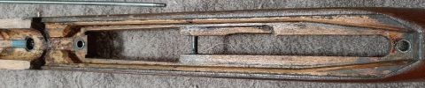 2003 Ford F-250 - This image shows a close-up view of a wooden rifle stock, with metal components visible within the stock's internal channels. A metal rod l…