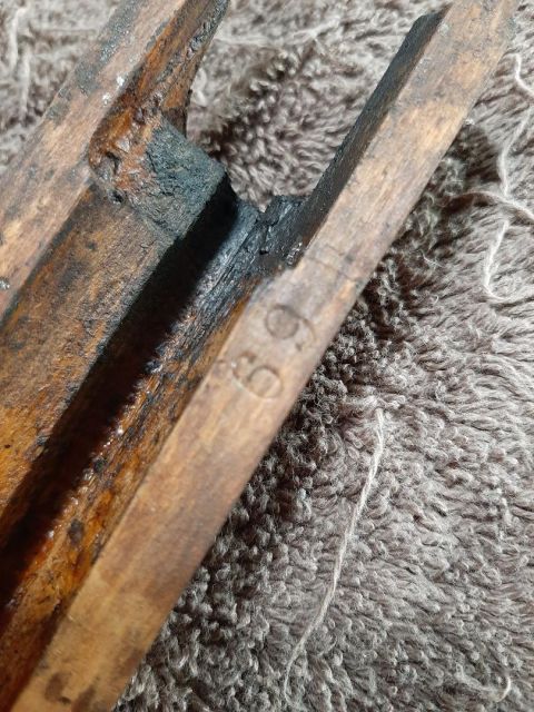 2003 Ford F-250 - A close-up shot of a worn wooden object with the number "69" carved into it. The object appears to be part of a tool or a piece of machiner…