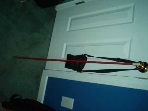 1988 Ford Bronco - A red rod with black straps is attached to a brass doorknob on a white door.