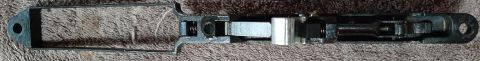 2003 Ford F-250 - This is a close-up, top-down view of a disassembled firearm mechanism, likely a bolt carrier group, resting on a brown, textured surface.