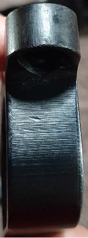2003 Ford F-250 - A close-up, side view of a dark-colored, metallic part with visible horizontal machining marks and some minor surface imperfections.