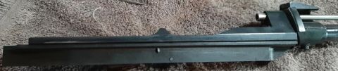 2003 Ford F-250 - This is a close-up, side view of a firearm bolt carrier group resting on a textured fabric surface.