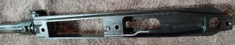 2003 Ford F-250 - This is a close-up, top-down view of a disassembled firearm receiver, likely an AR-15 style rifle, resting on a textured surface.