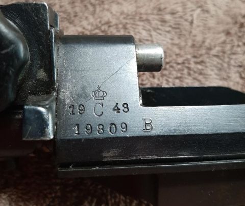 2003 Ford F-250 - A close-up view of markings on a metal object, possibly a firearm component. The markings include a crown symbol, numbers "19 C 43", "19809…