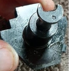 2003 Ford F-250 - A close-up, angled shot shows a dark-colored metal automotive part with a crescent-shaped lever on top. The part appears to be a component…