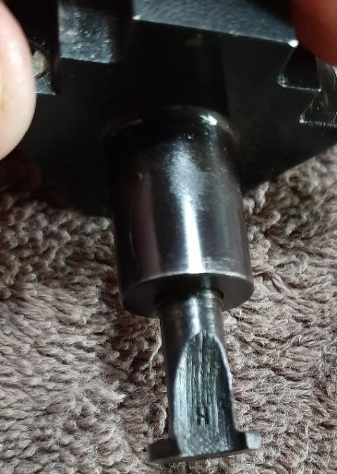 2003 Ford F-250 - A close-up view shows a metal part with a slotted end, possibly a tool or component, resting on a textured brown surface.