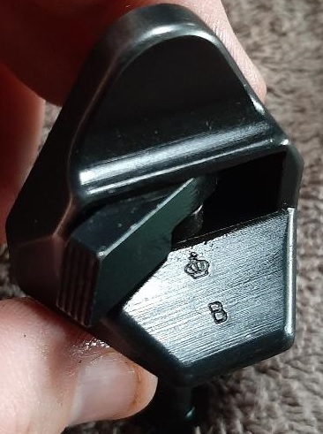 2003 Ford F-250 - A close-up shot shows a black metal part with a crown symbol and the letter 'B' stamped into it. The part appears to be a component of a ve…
