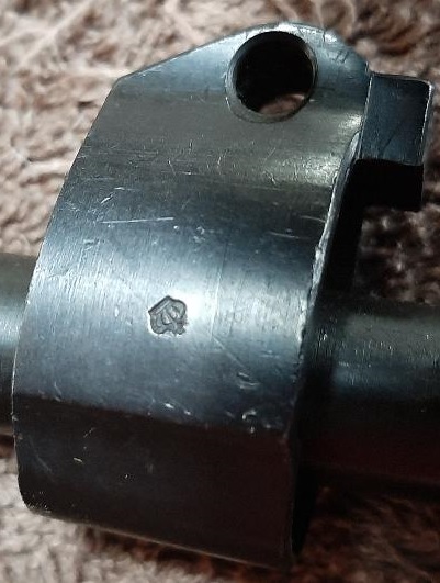 2003 Ford F-250 - A close-up shot of a metal part with a small symbol stamped on it. The background appears to be a textured surface.