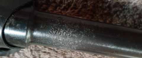 2003 Ford F-250 - A close-up shot shows the serial number "37606" stamped onto a dark, metallic cylindrical part, possibly a firearm barrel or a vehicle comp…