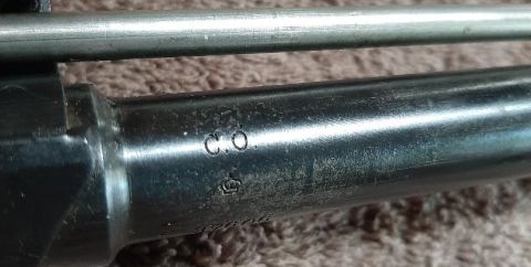 2003 Ford F-250 - A close-up view shows markings on a metallic cylindrical part, possibly a firearm barrel, with the letters "C.O." and a crown symbol stampe…