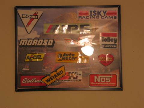 1995 Ford Bronco - A framed collection of decals from various automotive performance part manufacturers is displayed on a wall.