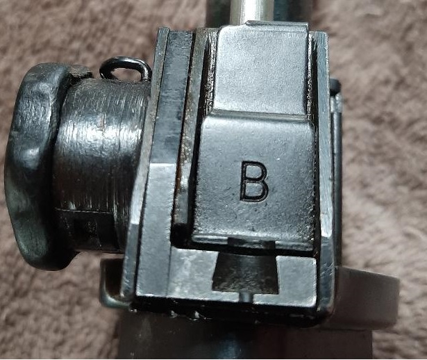 Close-up of a metal part with the letter B stamped on it.