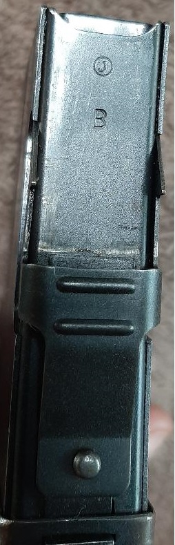 2003 Ford F-250 - A close-up view of a metal firearm magazine with markings 'J' and 'B' visible on its side.