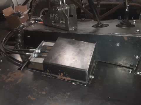 1985 Toyota Hilux - A close-up view of the interior of a custom vehicle, showing a metal fabricated center console with shifter mechanisms and cables. The cons…