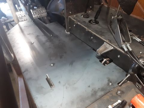 1985 Toyota Hilux - The interior of a vehicle shows a metal floor with pedals and a transmission shifter. Various metal plates and brackets are bolted and weld…